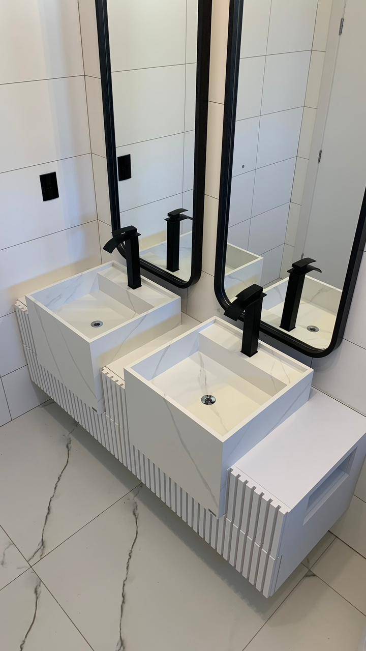 Cuba esculpida em porcelanato branco acetinado com ralo oculto e calha técnica.